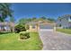 Front view of a yellow house with a paved driveway and well-maintained lawn at 1608 Forest Hills Ln, Haines City, FL 33844
