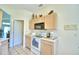 Kitchen features white appliances and light wood cabinets at 1608 Forest Hills Ln, Haines City, FL 33844