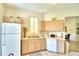 Bright kitchen with white appliances and light wood cabinets at 1608 Forest Hills Ln, Haines City, FL 33844