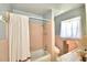 Bathroom with pink tile, shower/tub combo, and a window at 1950 El Paso Trl, Bartow, FL 33830