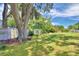 Large grassy backyard with mature oak tree and white fence at 1950 El Paso Trl, Bartow, FL 33830