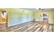 Open living area with hardwood floors, view of hallway, and access to bathroom at 1950 El Paso Trl, Bartow, FL 33830