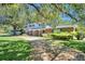 Brick home with covered entry, mature landscaping, and large oak trees at 1950 El Paso Trl, Bartow, FL 33830