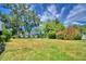 Expansive grassy backyard with flowering bushes and large trees at 1950 El Paso Trl, Bartow, FL 33830