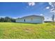 View of home's exterior, highlighting the light teal siding and backyard at 4073 Tullamore Ln, Auburndale, FL 33823