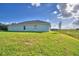 Single-story house with gray siding, a grassy yard, and a partial view of a pond at 4073 Tullamore Ln, Auburndale, FL 33823