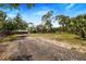 Gravel driveway leading to a large open area at 12510 Lake Hatchineha Rd, Haines City, FL 33844