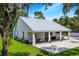 White modern farmhouse with covered patio, expansive lawn, and metal roof at 12510 Lake Hatchineha Rd, Haines City, FL 33844