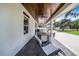 Covered patio with wood ceiling, outdoor dining furniture, and a large yard at 12510 Lake Hatchineha Rd, Haines City, FL 33844