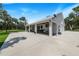 White modern farmhouse with covered patio, expansive lawn, and metal roof at 12510 Lake Hatchineha Rd, Haines City, FL 33844