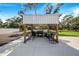 Outdoor kitchen area with covered pergola, grill, and seating at 12510 Lake Hatchineha Rd, Haines City, FL 33844