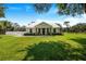 White farmhouse with metal roof and rocking chairs on porch at 12510 Lake Hatchineha Rd, Haines City, FL 33844