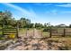 Metal gate with wooden fence posts along driveway at 12510 Lake Hatchineha Rd, Haines City, FL 33844