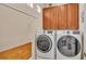 Laundry room with a washer, dryer, and wooden cabinets at 318 Crescent Ridge Rd, Auburndale, FL 33823