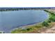 Aerial view showcasing a lakefront property with lush landscaping and a boat at 318 Crescent Ridge Rd, Auburndale, FL 33823
