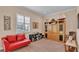 Versatile bonus room with a red couch, built-in shelving, and hardwood floors at 318 Crescent Ridge Rd, Auburndale, FL 33823