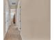 View down a hallway with neutral colored walls and carpeted flooring at 318 Crescent Ridge Rd, Auburndale, FL 33823