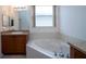 Bathroom with corner bathtub and wood vanity at 4568 Back Nine Dr, Winter Haven, FL 33884