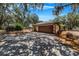 Attached garage with a brown door, surrounded by trees at 8881 Cypresswood Dr, Lake Wales, FL 33898