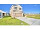 Two story house with tan siding, a two car garage, and landscaping at 1472 Leamington Ln, Winter Haven, FL 33884