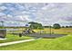 Community playground with swings, slides, and a shaded area at 1472 Leamington Ln, Winter Haven, FL 33884
