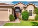Tan house with brown roof, screened porch, and landscaped yard at 4568 Back Nine Dr, Winter Haven, FL 33884