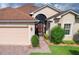 Tan house with brown roof, double garage, and landscaped front yard at 4568 Back Nine Dr, Winter Haven, FL 33884