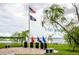 Peaceful memorial area with flag and plaques by the lake at 4568 Back Nine Dr, Winter Haven, FL 33884