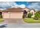Beige house with brown roof, two-car garage, and landscaped yard at 4568 Back Nine Dr, Winter Haven, FL 33884