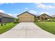 House exterior showcasing a two-car garage, well-manicured lawn, and attractive front entrance at 6421 Alamanda Hills Dr, Lakeland, FL 33813