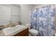 Clean bathroom with single sink, shower, and patterned curtain at 6421 Alamanda Hills Dr, Lakeland, FL 33813