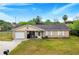 Brick ranch house with attached garage, driveway, and large yard at 329 N 19Th St, Haines City, FL 33844