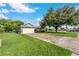Single-story home with a large tree and long driveway at 4353 Dinner Lake Dr, Lake Wales, FL 33859