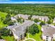 Aerial perspective of apartment buildings, parking, and green spaces at 8105 Coconut Palm Way # 204, Kissimmee, FL 34747