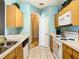 Kitchen with wood cabinets and a view of a hallway at 8105 Coconut Palm Way # 204, Kissimmee, FL 34747