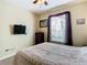 Bedroom with a double bed, dresser, and wall-mounted TV at 8105 Coconut Palm Way # 204, Kissimmee, FL 34747
