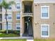 Exterior view of condo building with stairs and landscaping at 8105 Coconut Palm Way # 204, Kissimmee, FL 34747