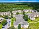 Apartment buildings, parking areas, and landscaping are shown in this aerial view at 8105 Coconut Palm Way # 204, Kissimmee, FL 34747