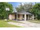 Brick home with covered porch, mature landscaping, and a basketball hoop at 2920 Gause St, Bartow, FL 33830