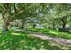 Brick pathway meanders through a lush park with large shade trees at 192 Viola Dr, Auburndale, FL 33823