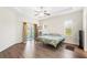 Main bedroom with wood flooring, a ceiling fan, and access to a private bathroom at 192 Viola Dr, Auburndale, FL 33823