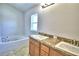 Bathroom with double vanity, granite countertop and soaking tub at 1269 Tagliamento Ln, Haines City, FL 33844