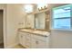 Double vanity bathroom with a large mirror and tile flooring at 1253 Tagliamento Ln, Haines City, FL 33844