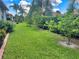 Landscaped backyard with lush lawn and mature tropical plants at 3093 Dunmore Dr, Lake Wales, FL 33859