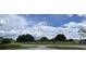Landscaped green space with mature trees and a paved road at 3130 Prairie Dunes W Cir, Lakeland, FL 33810