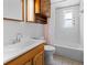 Bathroom with wood cabinet, white tub, and rainbow shower curtain at 1510 Richmond Rd, Lakeland, FL 33801
