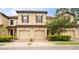 Tan three-unit townhouse with two-car garages and landscaping at 8153 Roseville Rd, Davenport, FL 33896