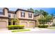 Tan three-unit townhouse with two-car garages and landscaping at 8153 Roseville Rd, Davenport, FL 33896