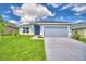 One-story home with gray siding, two-car garage, and a well-manicured lawn at 1273 Tagliamento Ln, Haines City, FL 33844