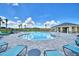 Community pool with lounge chairs and a covered patio at 1261 Tagliamento Ln, Haines City, FL 33844